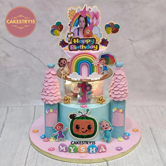3kg pineapple Cocomelon and Ms Rachel first birthday cake with pillars, rainbow, lights, and edible toppers from Cakestry15 Noida.