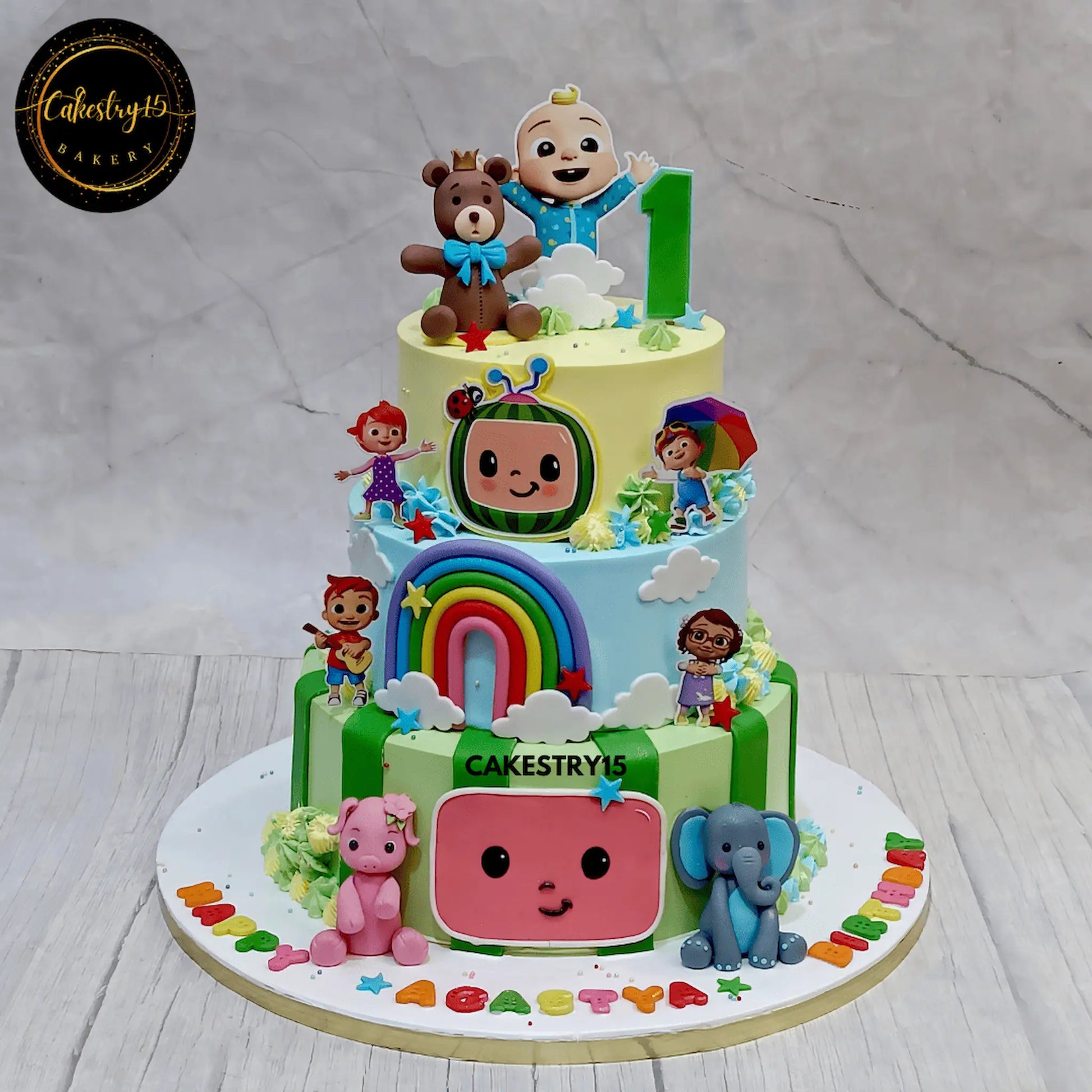 Cocomelon theme 3 tier first birthday cake with chocolate flavour and fondant characters eggless kids birthday cake in Noida
