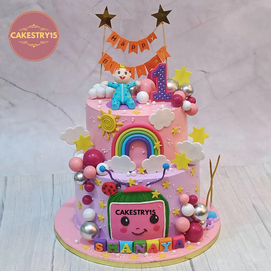 Eggless cocomelon theme first birthday cake with fondant figurine and rainbow design for kids in Noida