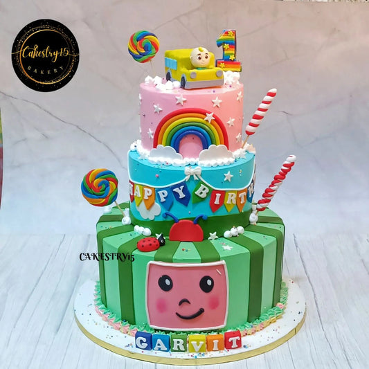 Eggless Cocomelon watermelon first birthday cake with rainbow balloons and chocolate tiers in Noida for kids celebration