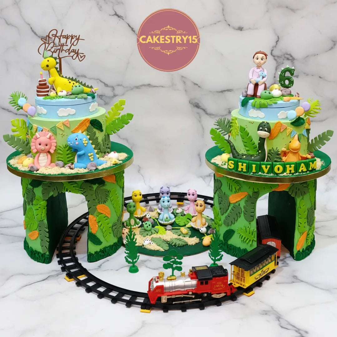 Dino theme kids birthday cake with two towers, dinosaur figurines, train and egg shells for a 6th birthday celebration in Noida.