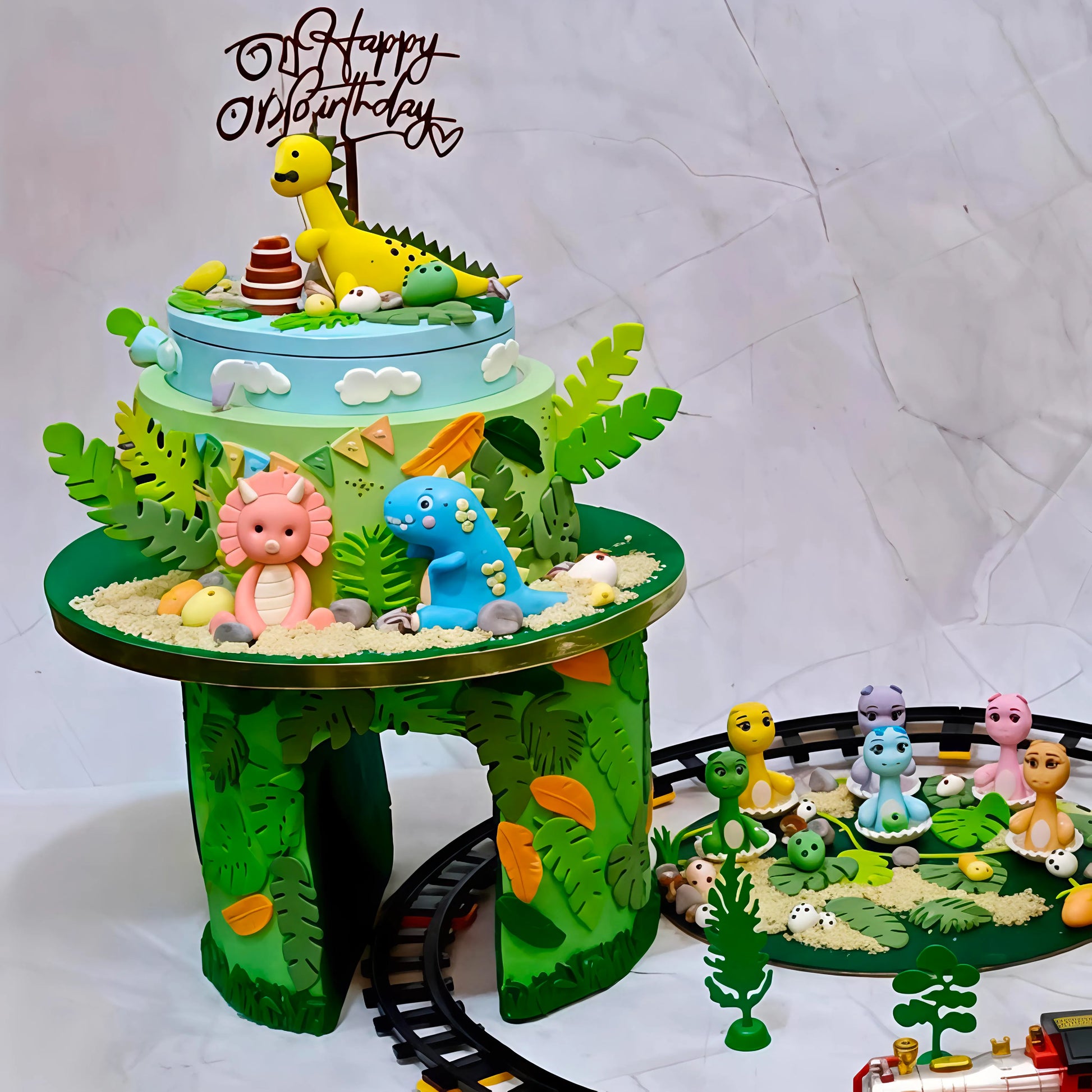 Dino theme cake tower with dinosaur figurines and green leaves, created as a custom eggless theme cake in Noida.