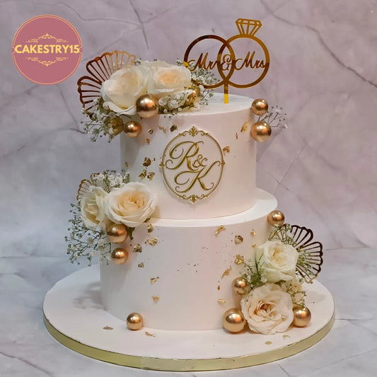 Elegant floral theme cake Noida featuring fresh roses, gold accents and marble finish, handcrafted as premium eggless cakes for engagement celebrations.