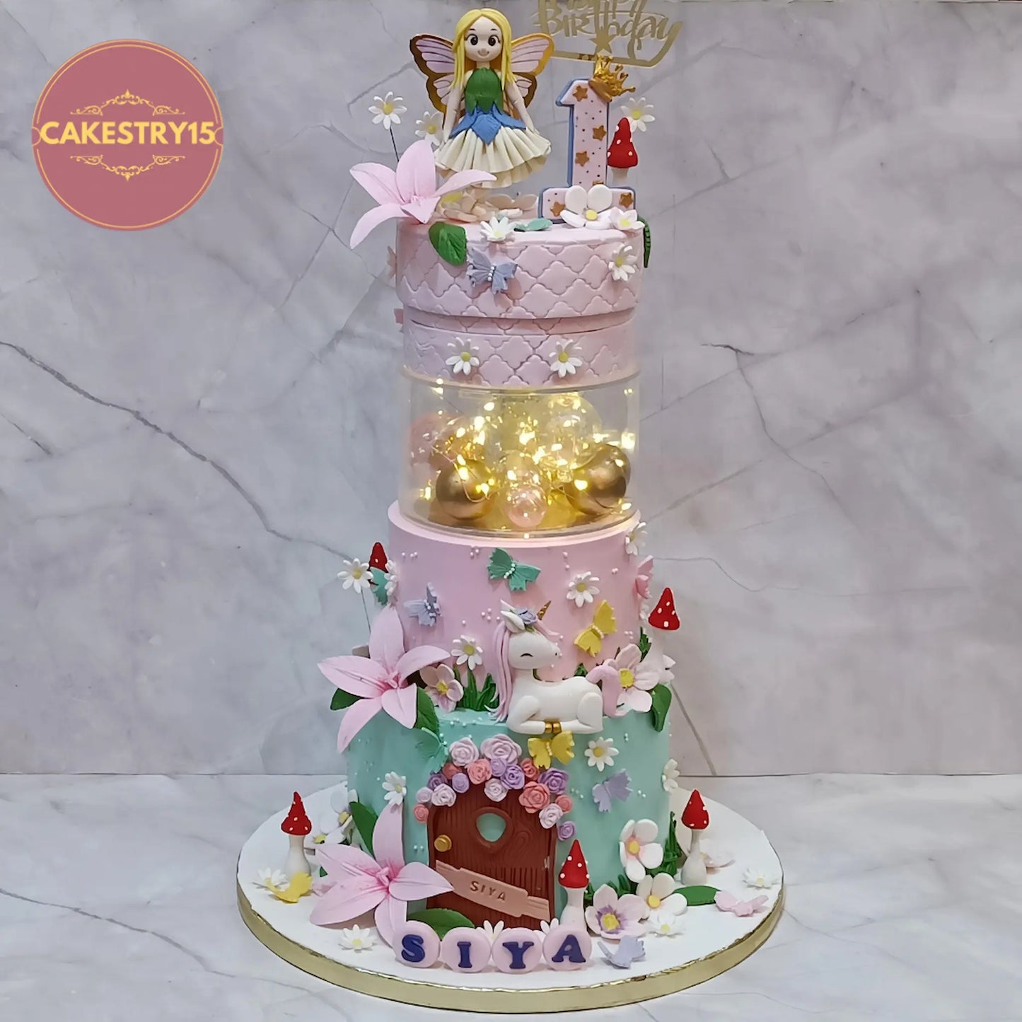 Fairy theme first birthday cake for girls in chocolate flavour with fairy figurine, unicorn and fondant decorations by Cakestry15 Noida