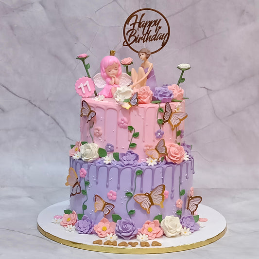 Fairy theme 11th birthday cake with pink and lavender icing, colourful flowers, leaves and a fairy topper.