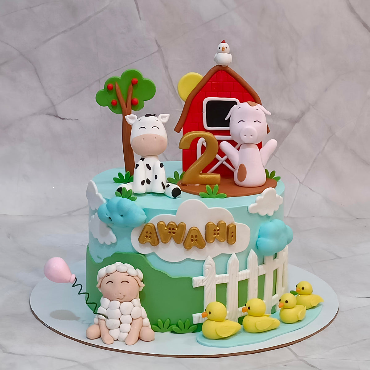 A decorated farm-themed kids birthday cake with fondant figures including a cow, pig, sheep, barn, ducklings, clouds, and the name in the front.