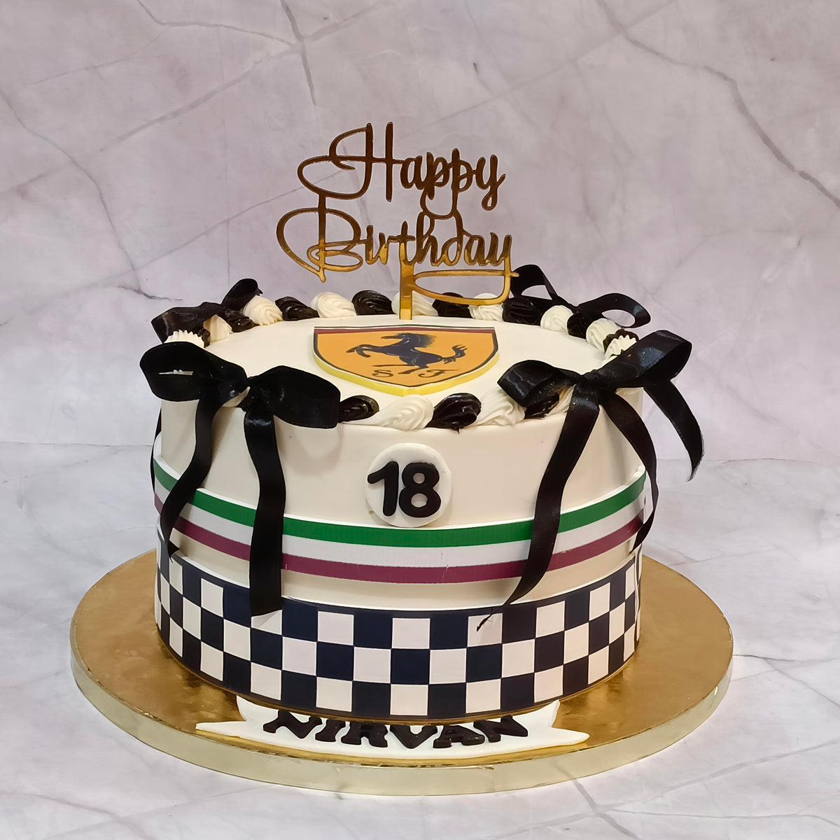 Ferrari theme 18th birthday chocolate cake with white ganache icing, Ferrari logo, racing track detailing and a satin black bow.