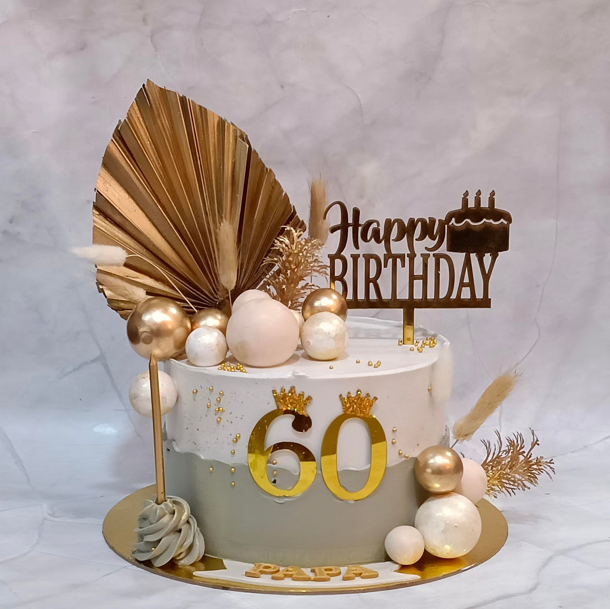Floral ferns 60th birthday cake decorated with faux balls, a golden candle, a birthday tag and a 60 tag.