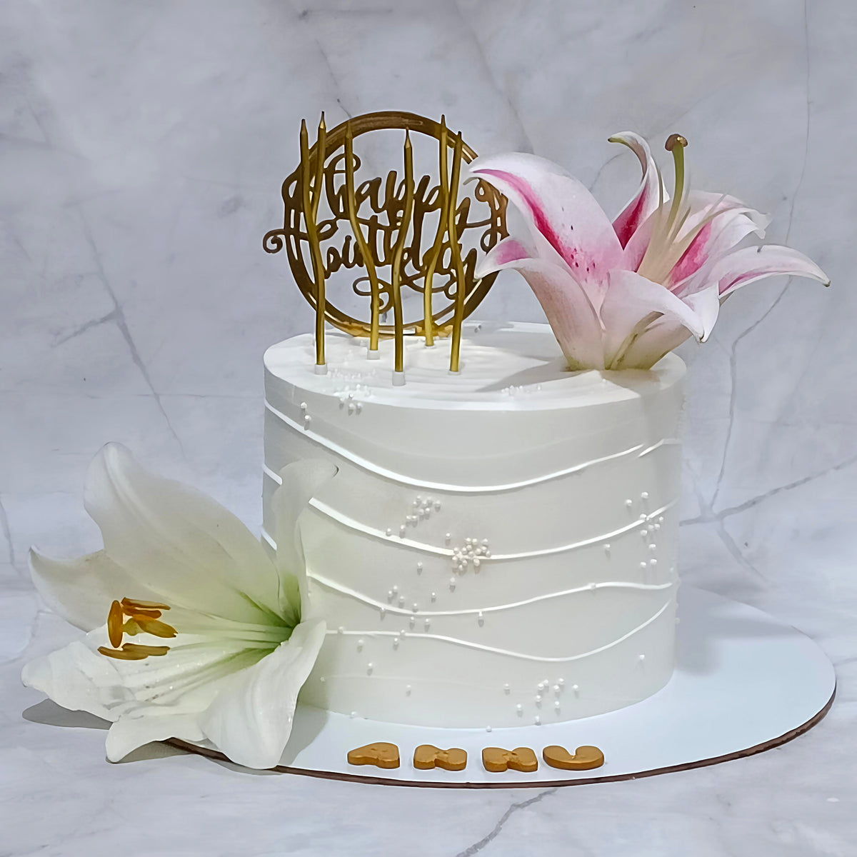 A floral lily birthday cake with two lilies from an eggless cakes bakery offering a theme cake Noida.