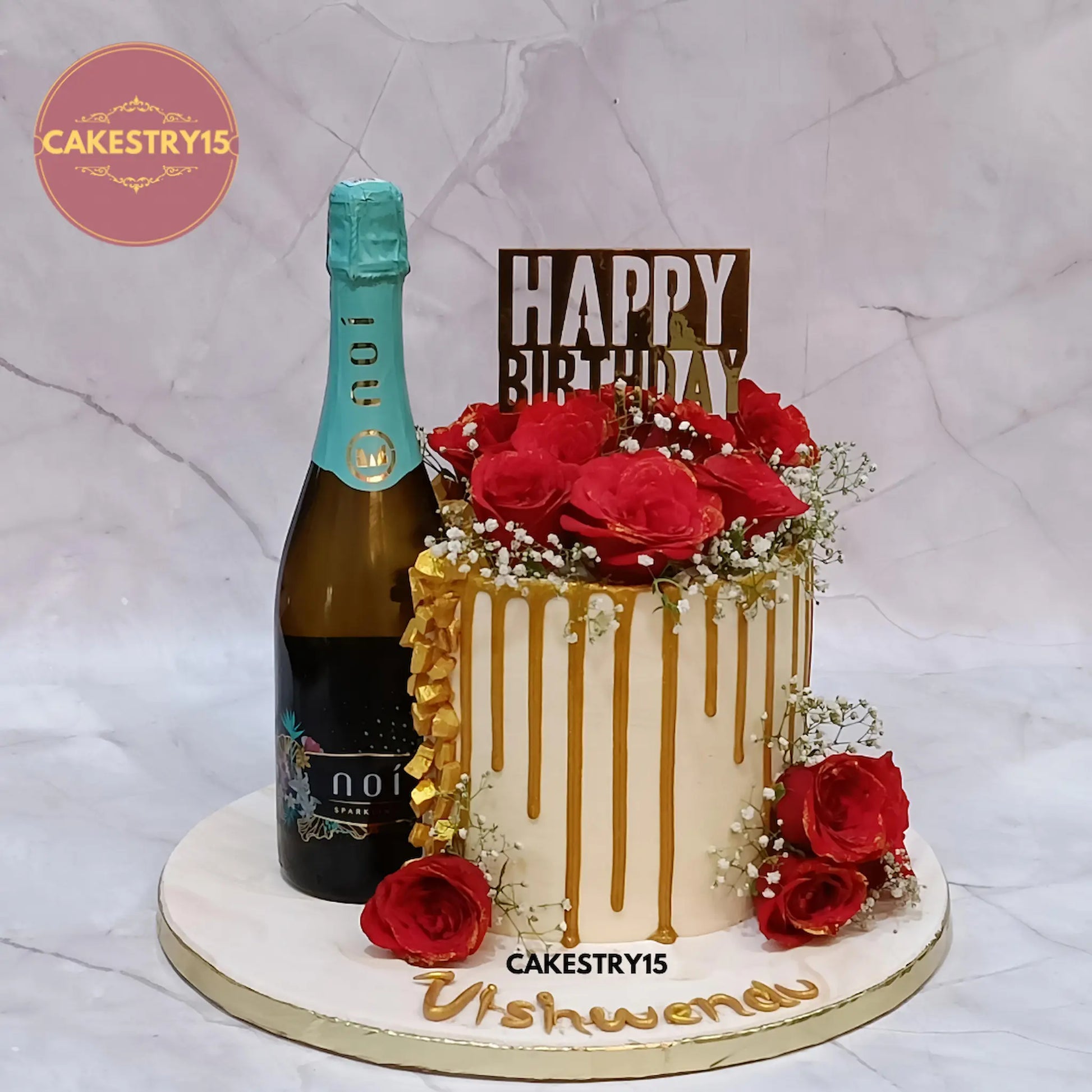 Golden Bliss wine theme eggless chocolate birthday cake with white ganache, golden accents, and fresh roses by Cakestry15 in Noida