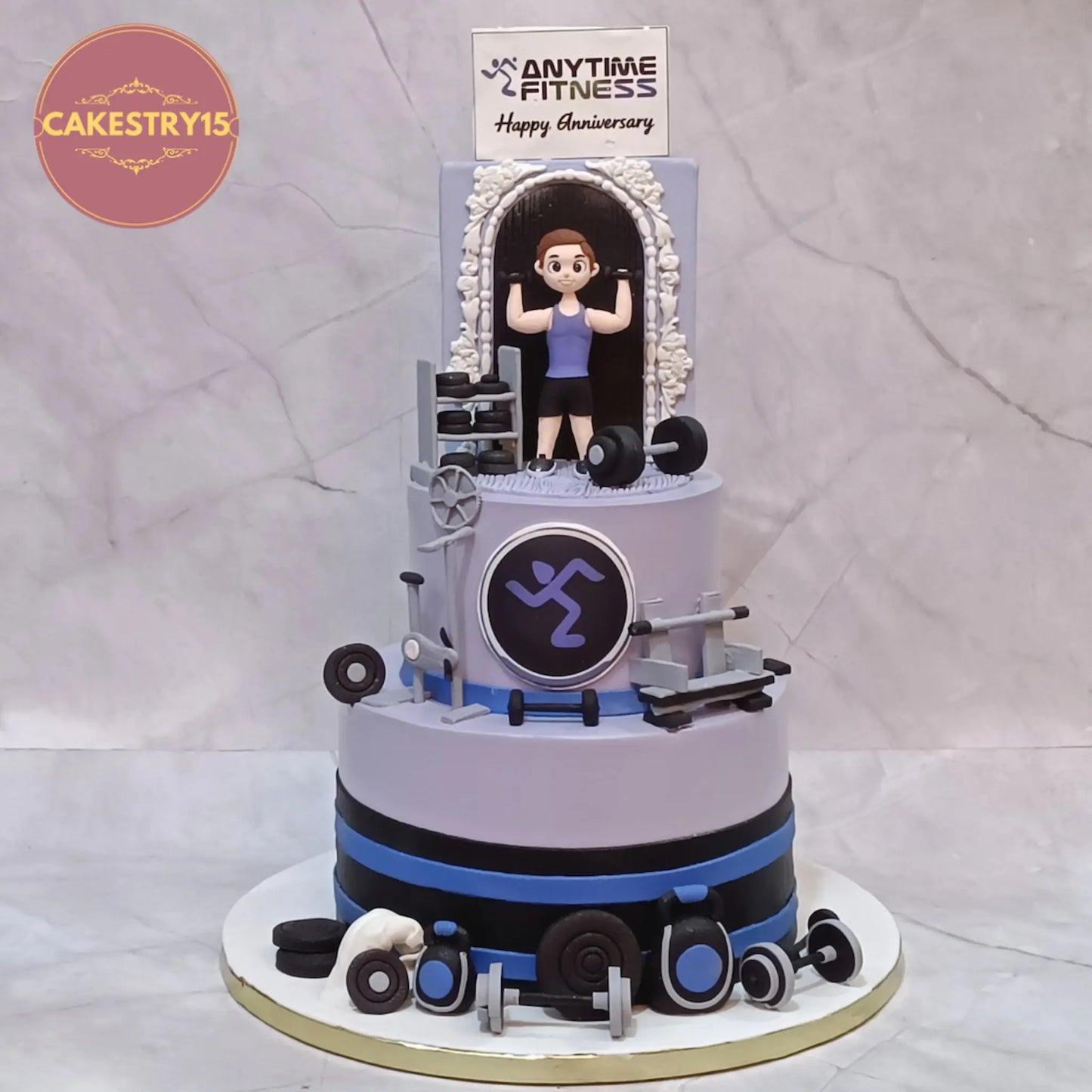 Eggless gym theme anniversary cake with weights, dumbbells, exercise topper and custom logo for corporate celebration in Noida