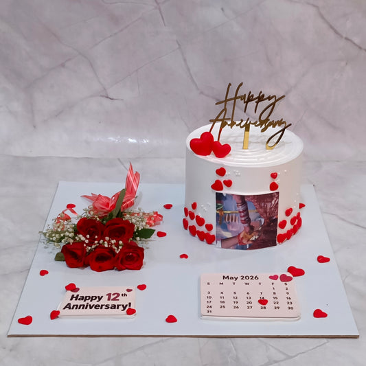Premium eggless happy 12th anniversary cake with edible couple image, fondant hearts, rose bouquet and personalised calendar, handcrafted in Noida.
