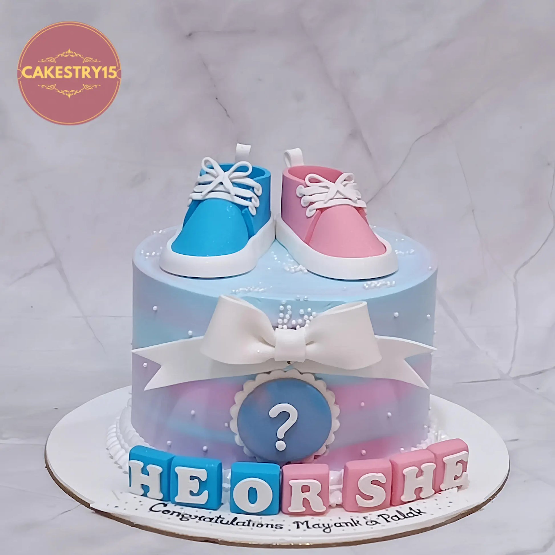 He or She baby shower cake in butterscotch flavour with blue and pink shoes, eggless theme cake in Noida by cakestry15