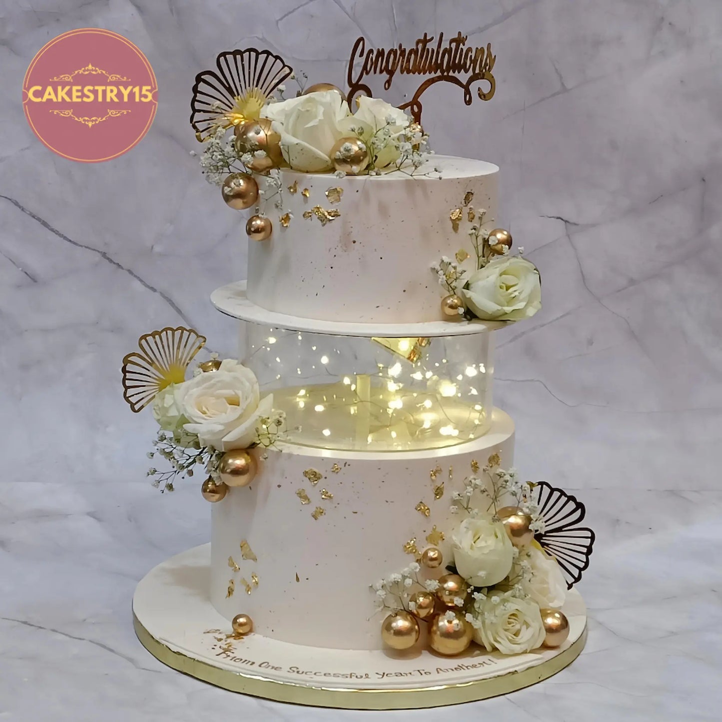 Elegant ivory corporate celebration cake with spacer, gold accents and roses, 5 kg eggless truffle cake in Noida by cakestry15