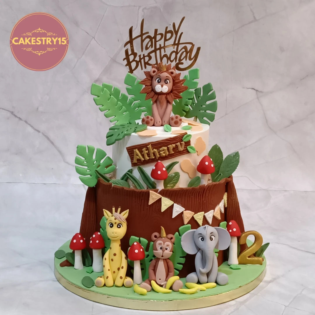 Jungle theme  kids 2nd birthday cake with fondant lion, giraffe, monkey and elephant, a premium theme cake Noida families choose from fresh eggless cakes by Cakestry15.
