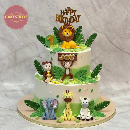 Eggless jungle theme first birthday cake with fondant lion, monkey, elephant, zebra and giraffe by Cakestry15 in Noida