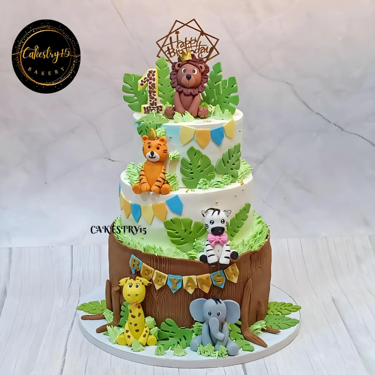 Eggless jungle theme kids birthday cake with fondant safari animals for first birthday celebration in Noida.