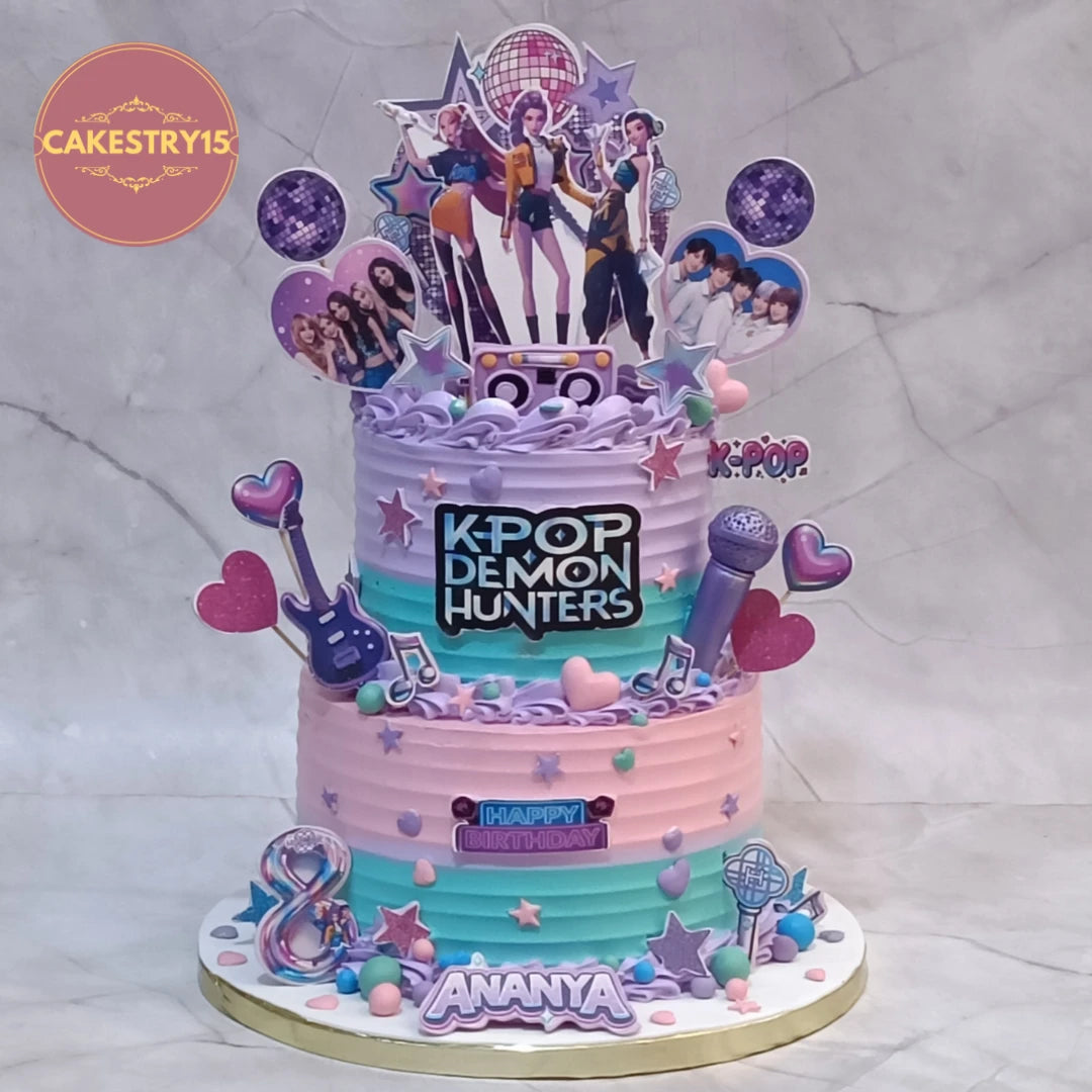 K Pop Demon Hunters concert theme kids birthday cake with music elements, disco balls and edible images, premium theme cake Noida made with fresh eggless cakes.
