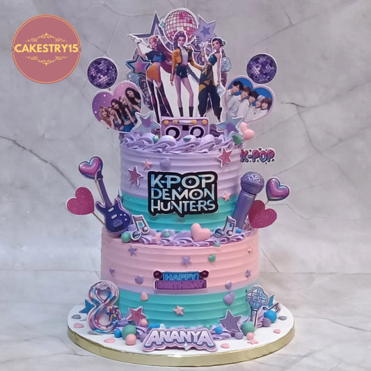 K Pop Demon Hunters concert theme kids birthday cake with music elements, disco balls and edible images, premium theme cake Noida made with fresh eggless cakes.
