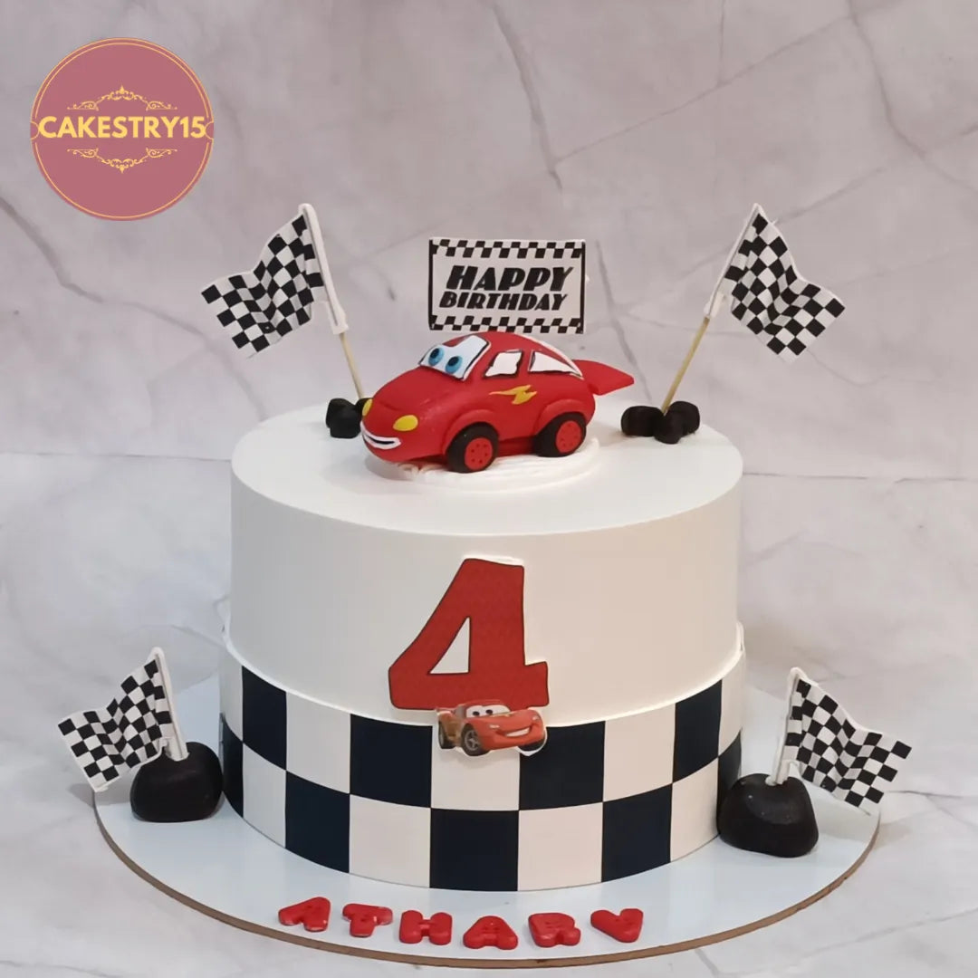 Eggless McQueen car kids birthday cake with racing theme design and blueberry flavour for theme cake delivery in Noida.