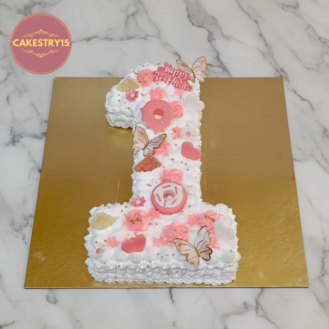 Number 1 kids birthday cake with fondant hearts, donuts and butterflies, from an eggless cakes bakery offering a theme cake Noida.
