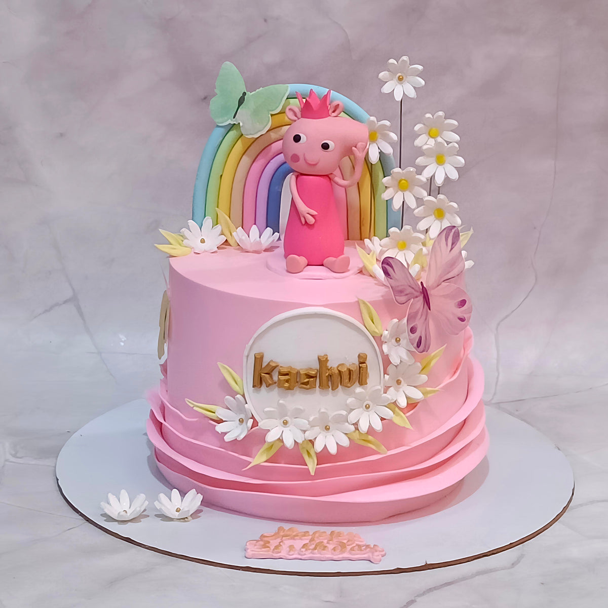 Peppa Pig theme 5th birthday cake for a girl with a Peppa Pig figurine, rainbow, white flowers and butterflies.