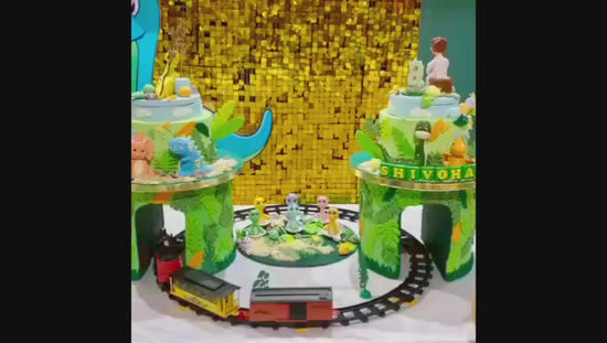Dino theme 6th birthday cake video showing the two-tower design, train, dinosaur figurines and egg shell details from Cakestry15 in Noida.