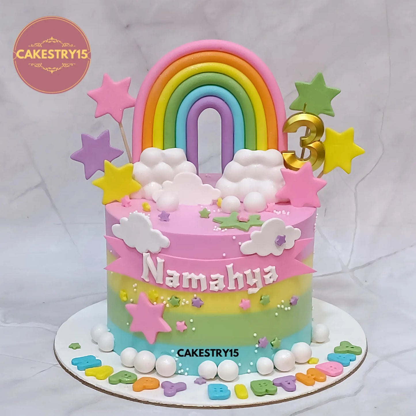 Eggless rainbow kids birthday cake with fondant rainbow, clouds and stars for a theme cake Noida celebration.