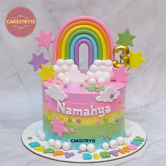 Eggless rainbow kids birthday cake with fondant rainbow, clouds and stars for a theme cake Noida celebration.