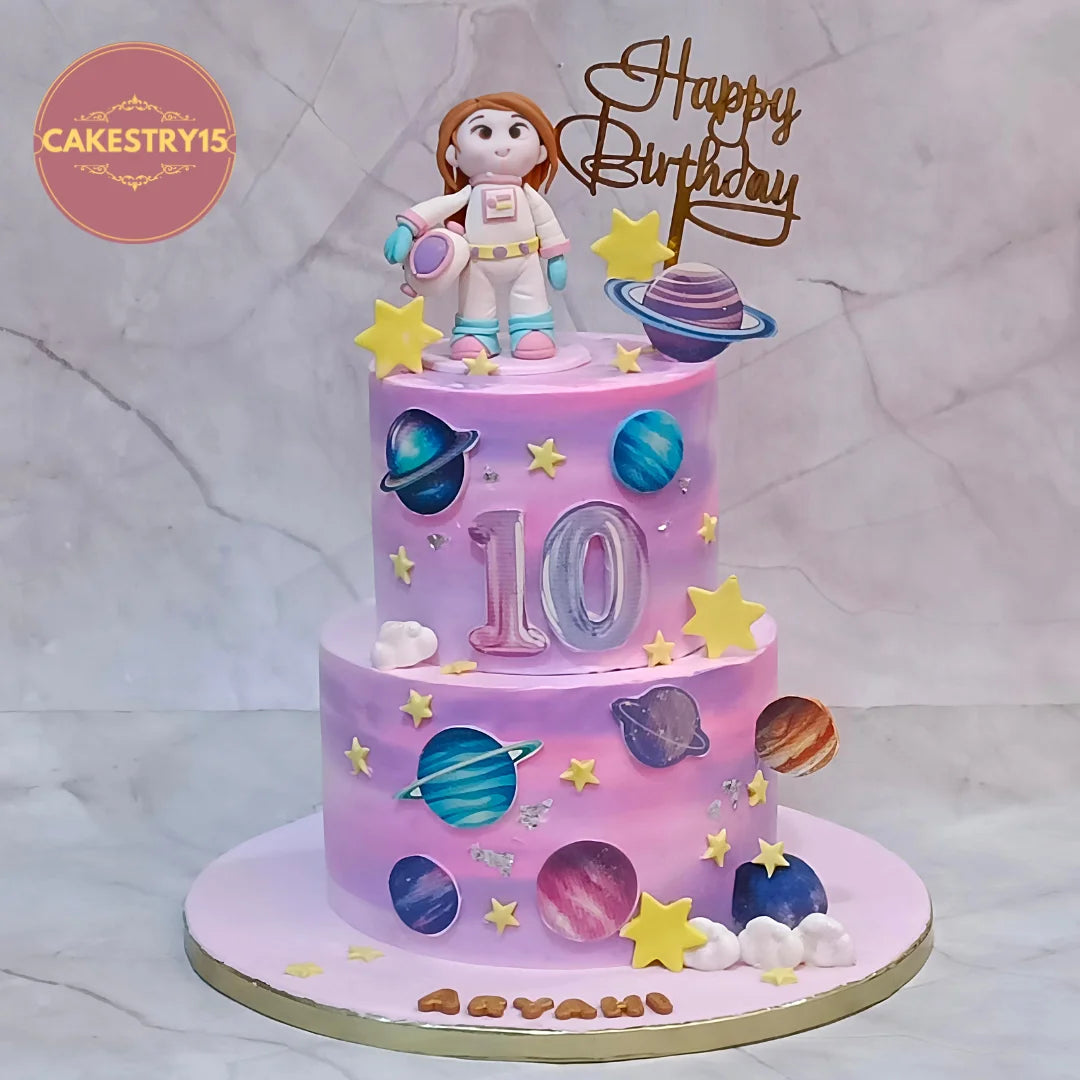 Space theme kids birthday cake with edible planets and a girl astronaut figurine from an eggless cakes bakery offering a theme cake Noida.