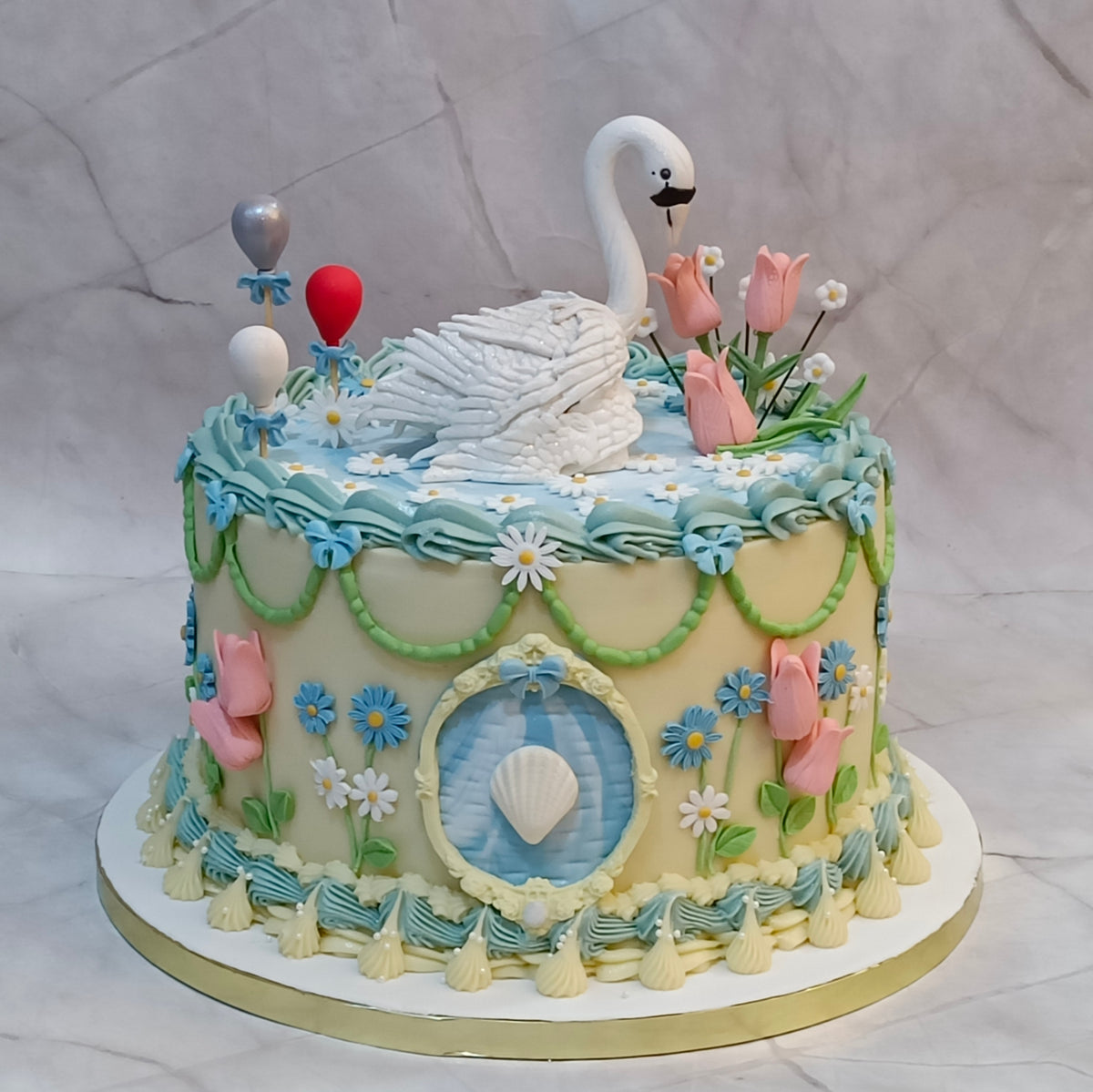 Elegant swan theme birthday cake with white ganache, tulips and floral details from our eggless cakes collection, available as a theme cake in Noida.