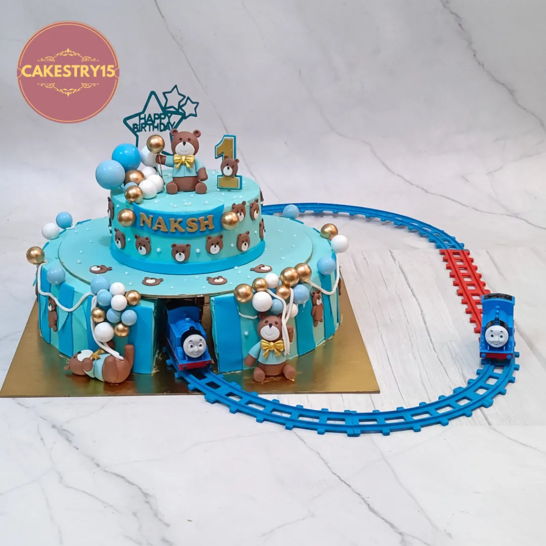 Teddy Thomas Train kids birthday cake with teddy figurines, a theme cake Noida design and eggless cakes for a first birthday.