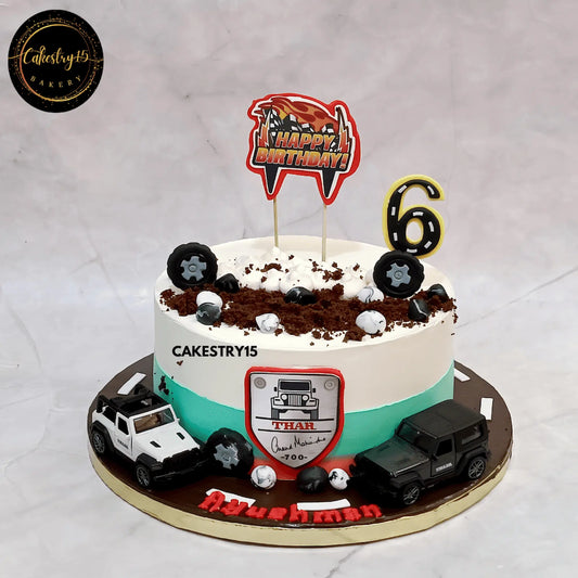 Eggless chocolate Thar theme kids birthday cake with toy cars and tyre detailing for a 6th birthday in Noida