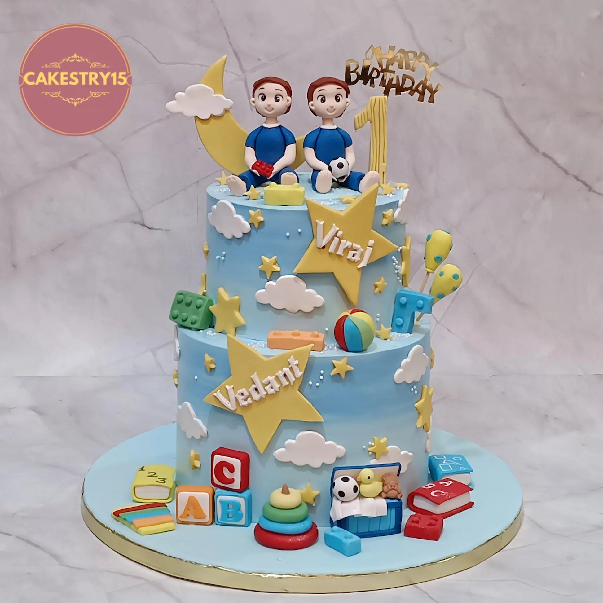 Eggless twin boys first birthday cake with figurines, stars and toys in choco vanilla flavour by Cakestry15 Noida