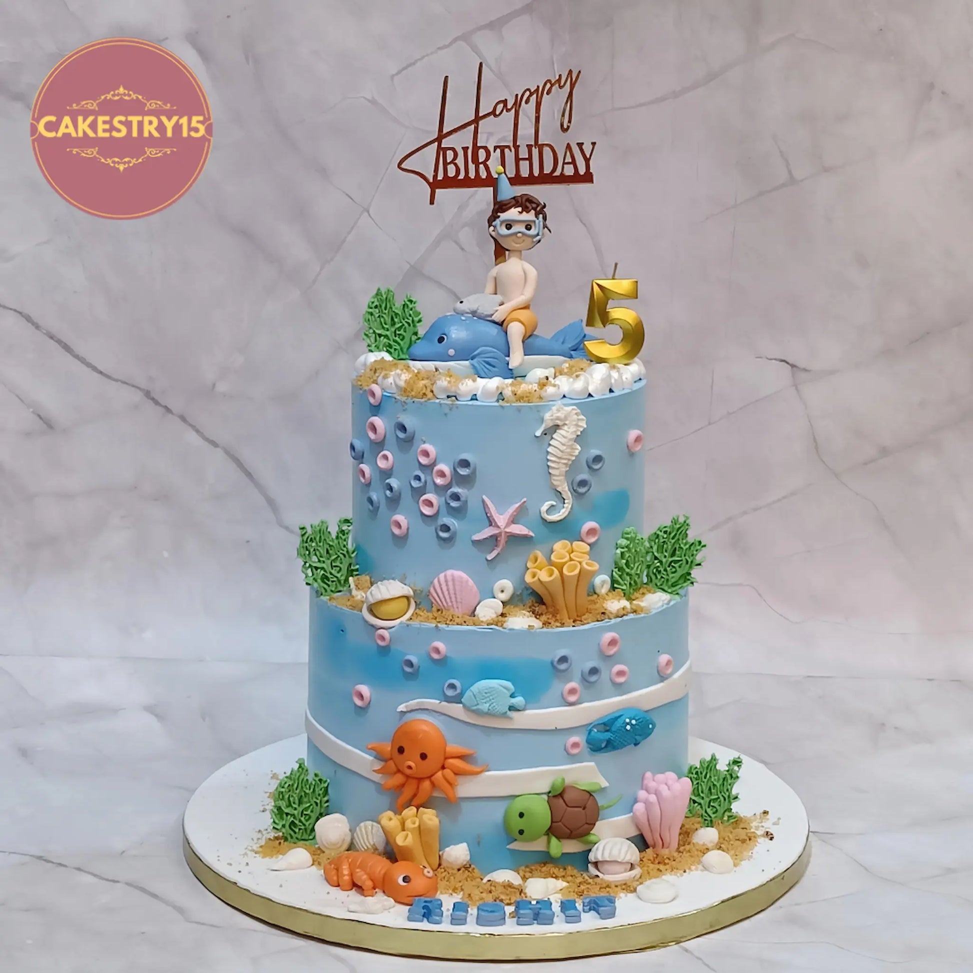 Under sea theme kids birthday cake with dolphin boy figurine and sea creatures eggless chocolate cake Noida