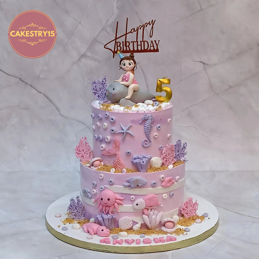 Under sea theme kids cake for 5th birthday Anvisha with dolphin girl topper and ocean elements in eggless choco vanilla flavour Noida