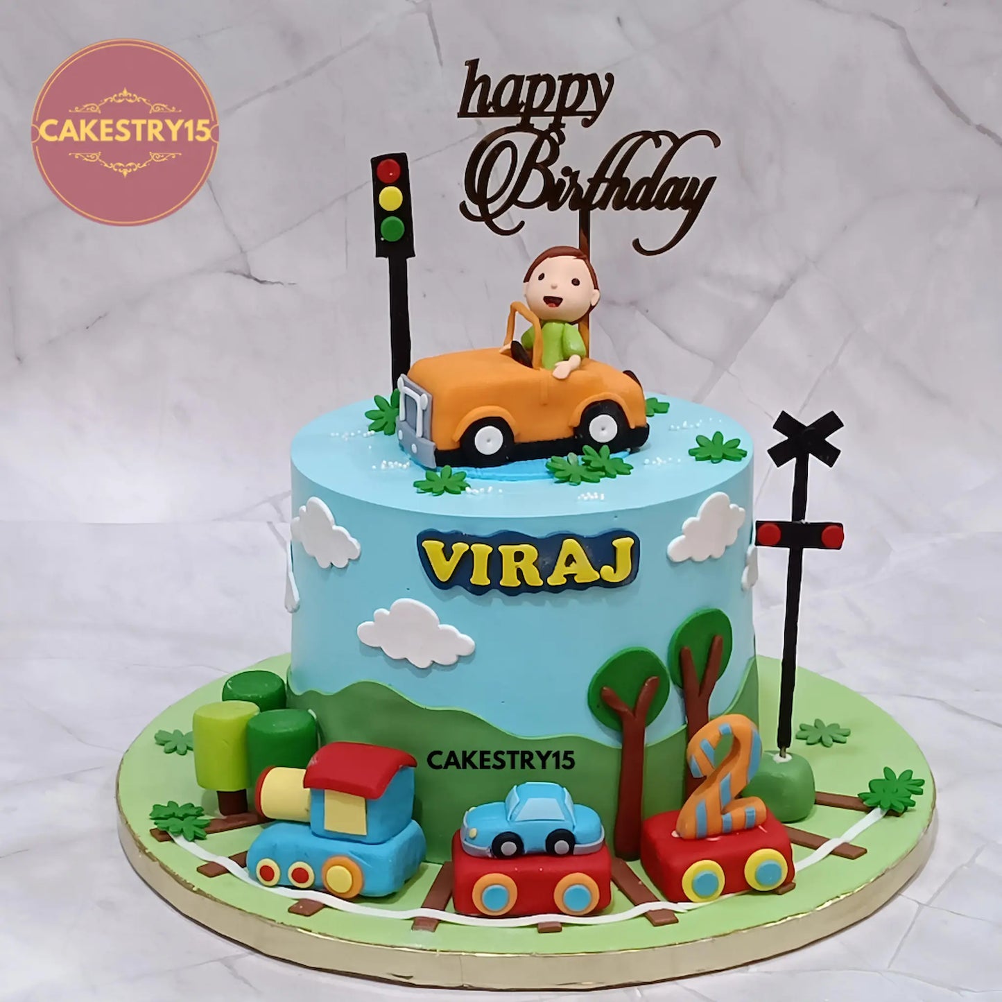 2kg eggless butterscotch car theme cake for 2nd birthday from Cakestry15 with car, boy figurine, clouds, trees, and train design
