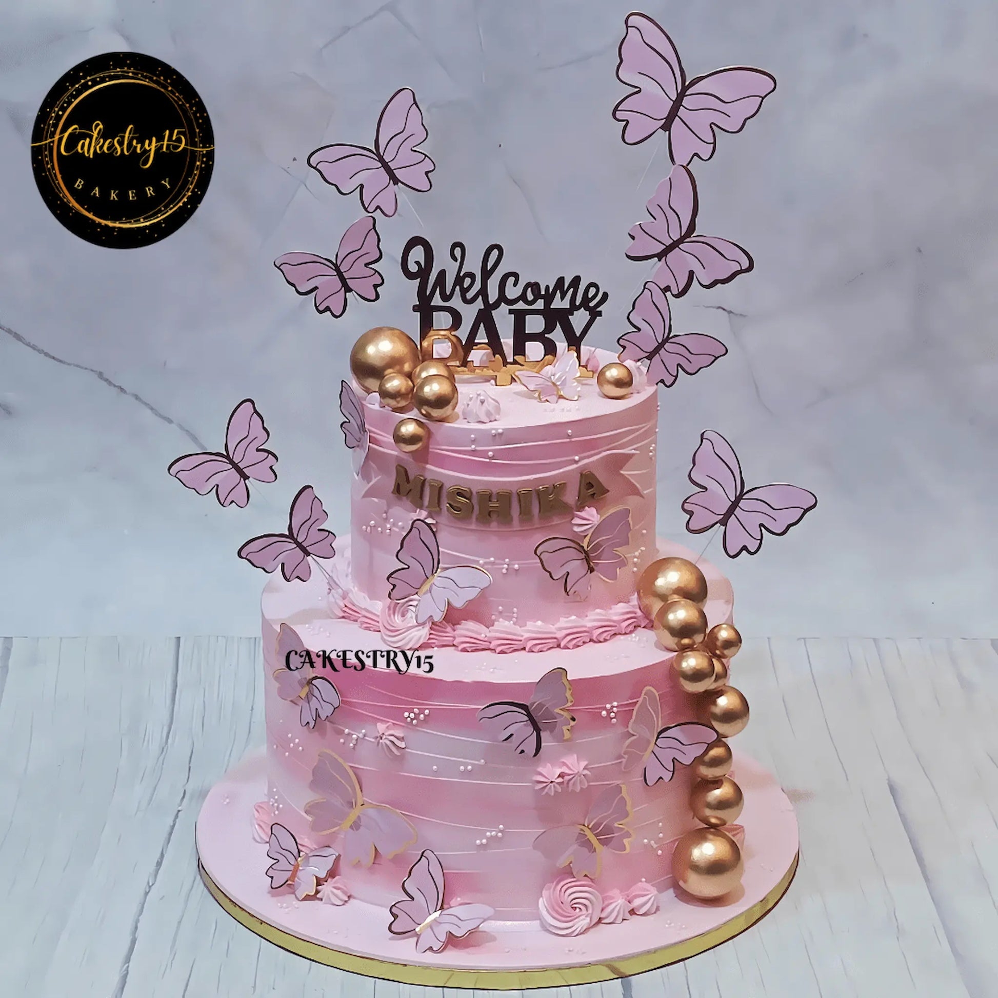 Eggless welcome baby black forest two tier cake with pink butterflies by Cakestry15 Noida