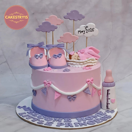 Welcome Baby Girl kids birthday cake featuring a sleeping baby figurine, baby shoes, clouds and milk bottle, handcrafted as a theme cake Noida using premium eggless cakes.