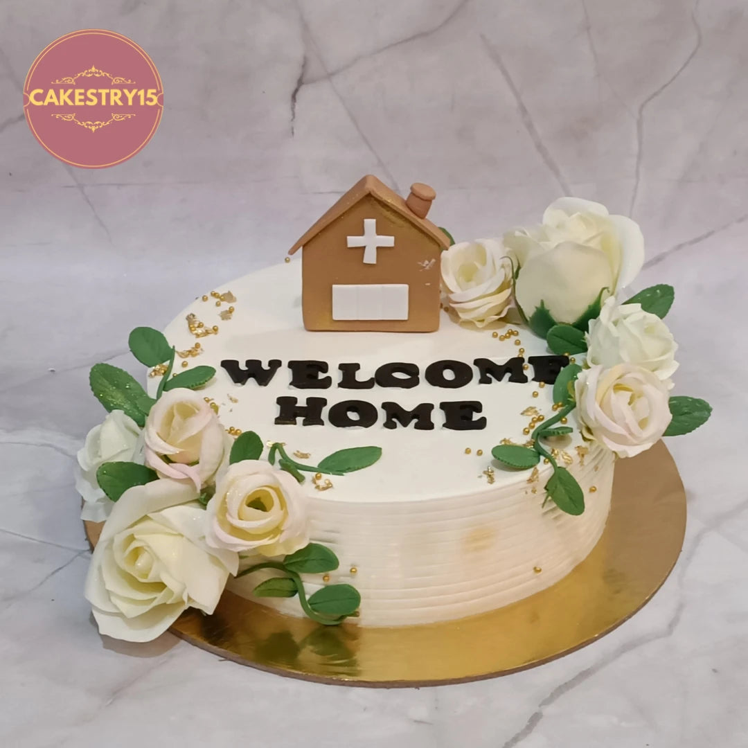 Elegant welcome home celebration cake with fondant house and fresh flowers, handcrafted as premium eggless cakes in Noida.