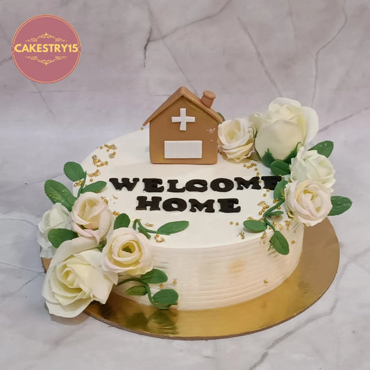 Elegant welcome home celebration cake with fondant house and fresh flowers, handcrafted as premium eggless cakes in Noida.