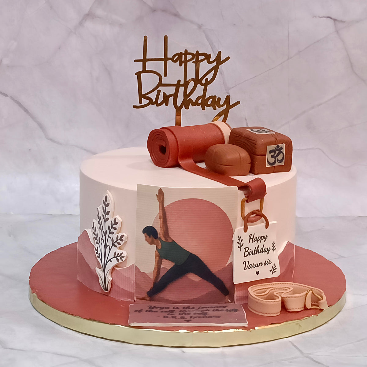 Yoga coach birthday cake with edible images of a person doing yoga, yoga mats and other yoga-related materials.
